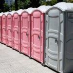 Gray and pink mobile bio toilets for men and women in park
